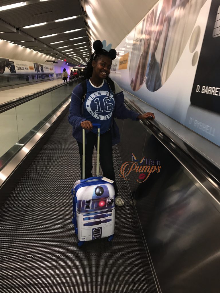 Brown Girl with Suitcase traveling to Disney World Pixie Dust