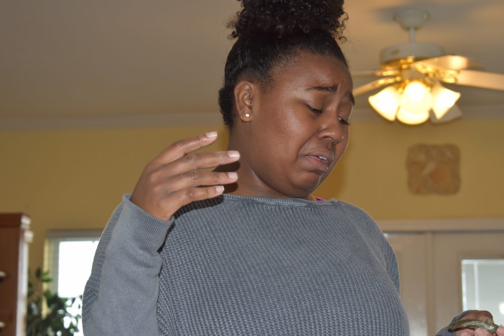 brown skin girl frowning from nasty food. taste testing oysters in Myrtle Beach for thanksgiving during the seafood broil