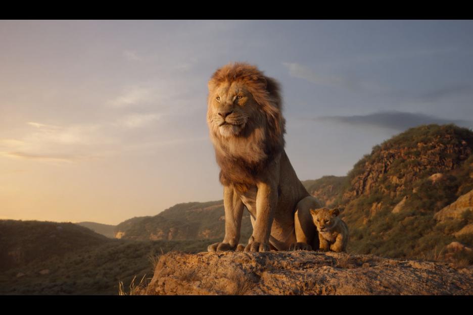 Young Simba and Mufasa sit upon Pride rock. Lion King Movie