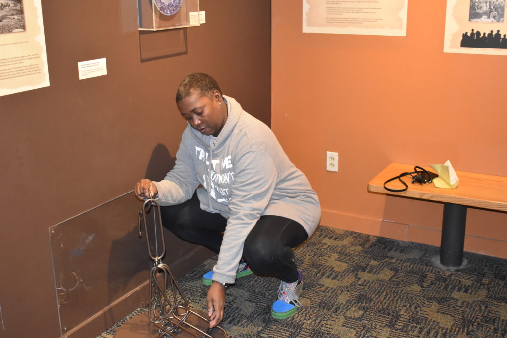 brown girl examining Rochester Museum Underground Railroad artifacts