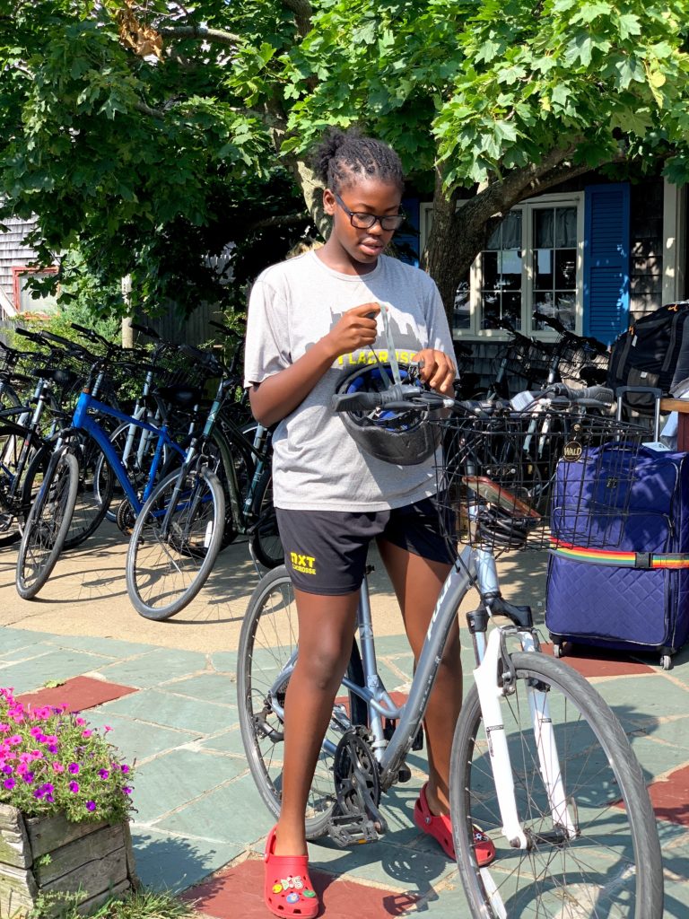 Brown girl biking in Marthas Vineyard sustainable travel